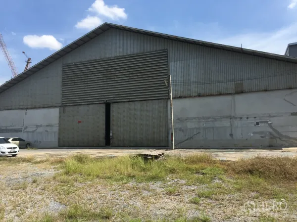 货栈 出租在Khlong Luang, Pathum Thani - 孔龙銮钢板外墙仓库外观，超大推拉门与装卸场地。