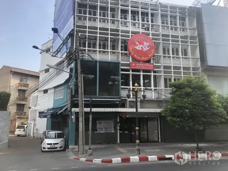 Retail Space for rent in Khlong Toei, Bangkok - Corner shophouse retail building with grid facade and prominent round signage on a Sukhumvit side street.