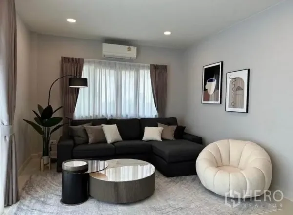 บ้าน ให้เช่าในBang Phli, Samut Prakan - ห้องนั่งเล่นสว่างด้วยโซฟาเข้ามุม เก้าอี้ทรงกลม โคมไฟยืน และผ้าม่านเต็มบาน