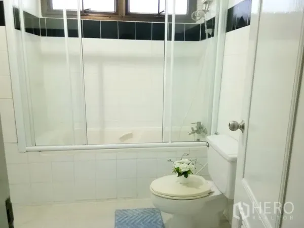 Condominium for rent in Watthana, Bangkok - Bathroom with shower-over-bathtub, glass enclosure and white tiles.