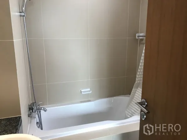 公寓 出租在Watthana, Bangkok - 浴室采用米色墙砖，设有浴缸与手持花洒。