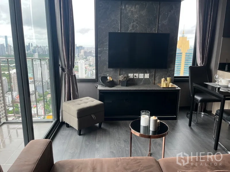 คอนโด ให้เช่าในWatthana, Bangkok - ห้องนั่งเล่นสไตล์โมเดิร์น ผนังทีวีหินอ่อน ระเบียง และวิวสกายไลน์กรุงเทพฯ