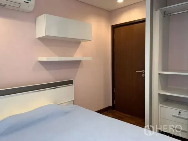 公寓 出租在Watthana, Bangkok - 次卧带置物架、衣柜与淡色墙面。