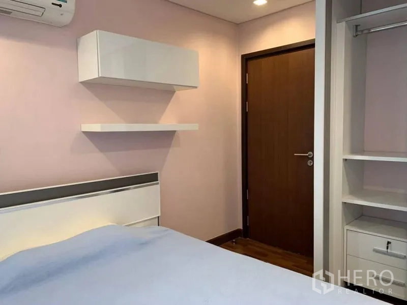 公寓 出租在Watthana, Bangkok - 次卧带置物架、衣柜与淡色墙面。