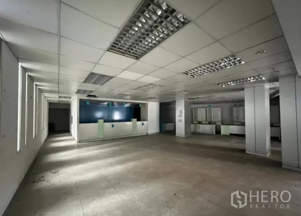 Shophouse for rent or sale in Khlong Toei, Bangkok - Wide retail hall with multiple service counters, columns, and tiled flooring.