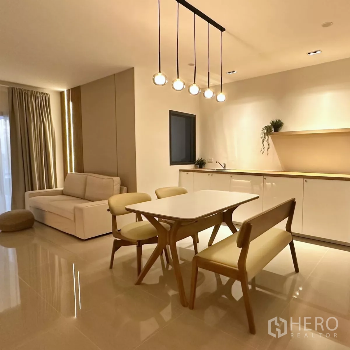 联排别墅 出租在Bang Phli, Samut Prakan - 傍晚客厅，沙发、落地窗帘与暖色灯光。