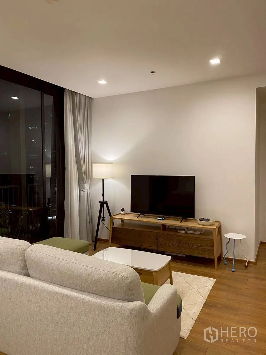 คอนโด for rent in Watthana, Bangkok - มุมทีวีตอนค่ำพร้อมโคมไฟขาตั้งและหน้าต่างบานใหญ่
