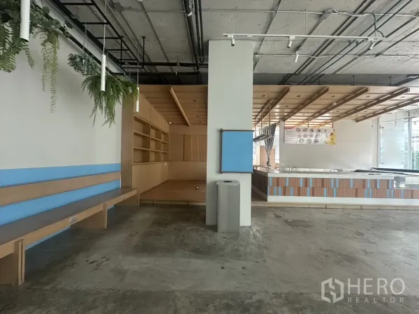 Retail Space for rent - Open-plan shop area with built-in bench seating, hanging greenery, shelving, and track lighting.
