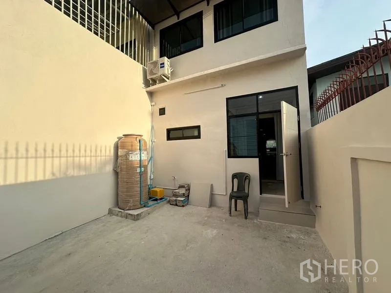 Townhouse for rent or sale in Phra Khanong, Bangkok - Second bathroom with floating vanity, mirror and toilet in grey tiles.