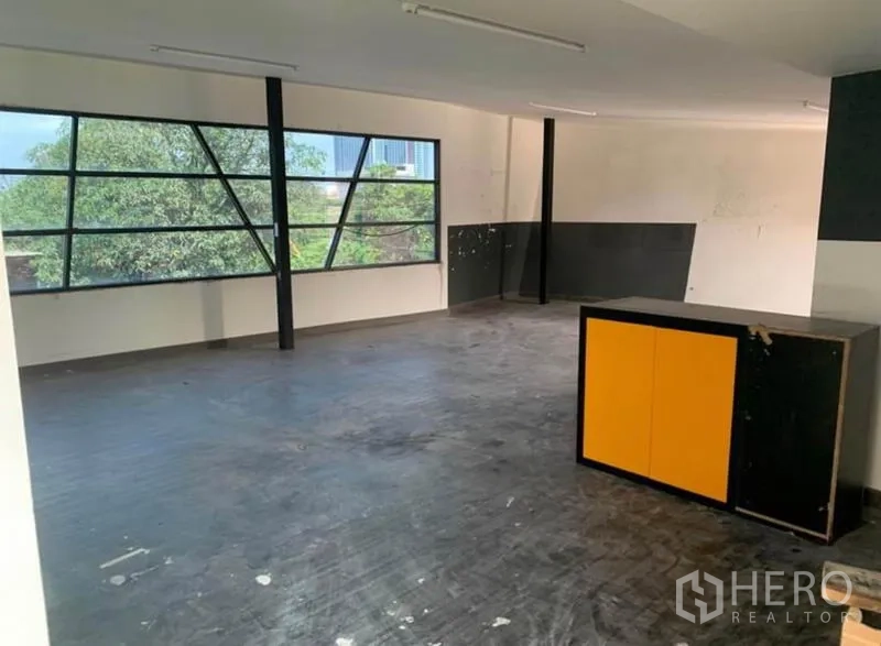Warehouse for rent in Samut Prakan - Second-floor office space with large corner windows providing natural light and yard views.