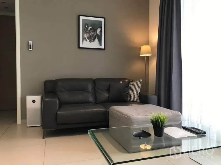 公寓 出租在Watthana, Bangkok - 明亮客厅，皮沙发与大窗户，曼谷瓦他那区公寓