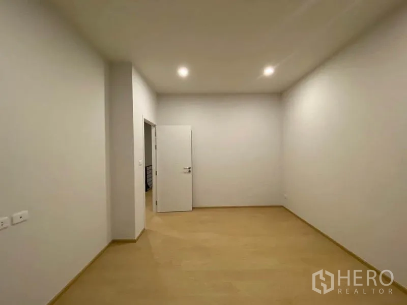 联排别墅 出租在Prawet, Bangkok - 空房间柔和照明，门开启通向走廊。