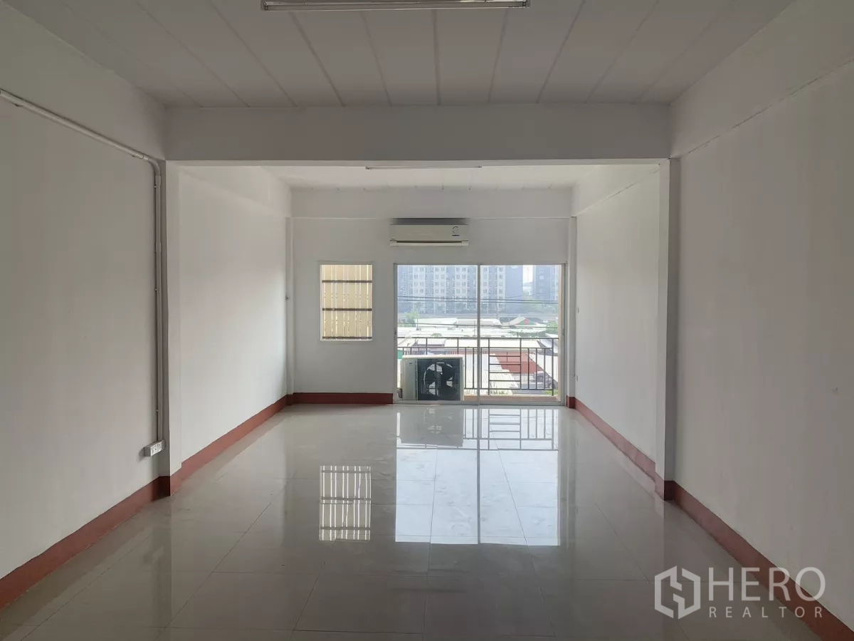 Home Office for rent in Lat Krabang, Bangkok - Bright office room with air‑conditioner, sliding glass to a small balcony and city view.