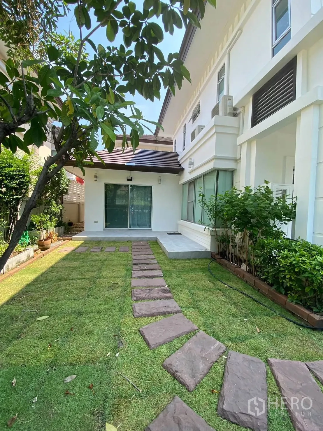 独栋房屋 for rent in Mueang Samut Prakan, Samut Prakan - 后院草坪与通往露台的石径。