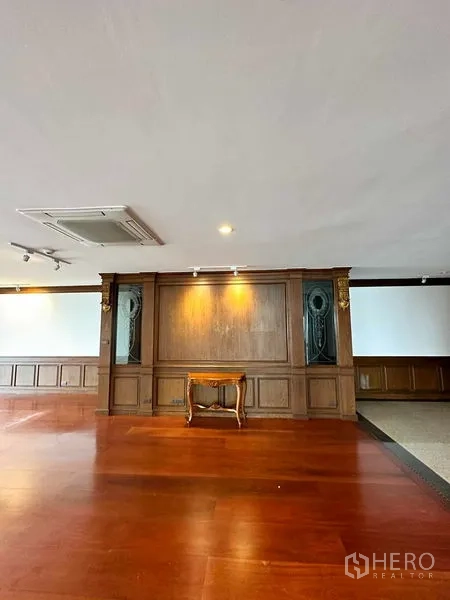 Condominium for rent in Bangkok - Feature wall with spotlighting and polished timber floor in the lounge.
