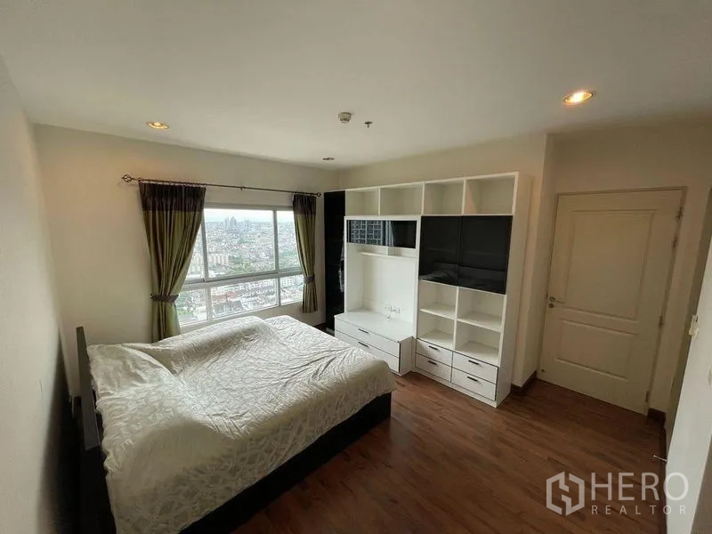 Condominium for sale - Master bedroom with large window city views and built-in shelving and TV unit.