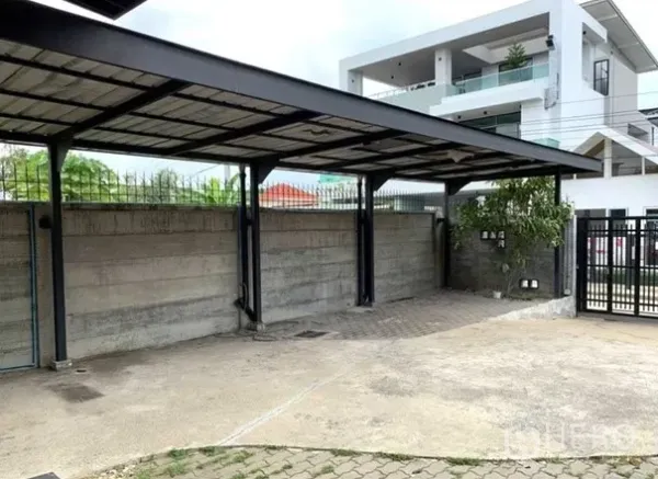 Home Office for rent in Lat Phrao, Bangkok - Covered parking bays along a concrete wall with a steel canopy.