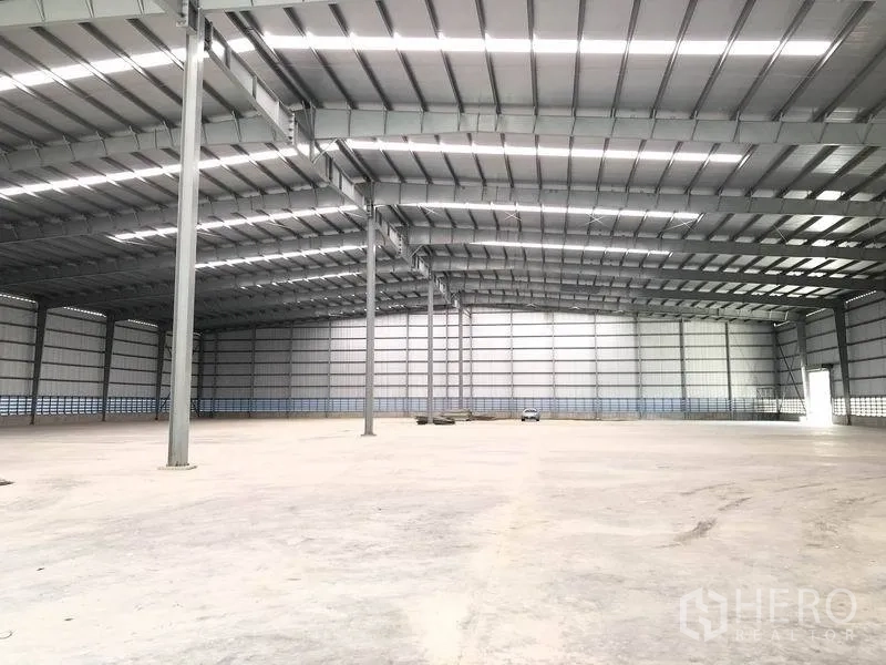 Factory for rent in Bang Phli, Samut Prakan - Expansive empty production hall with tall steel columns and ample natural lighting.