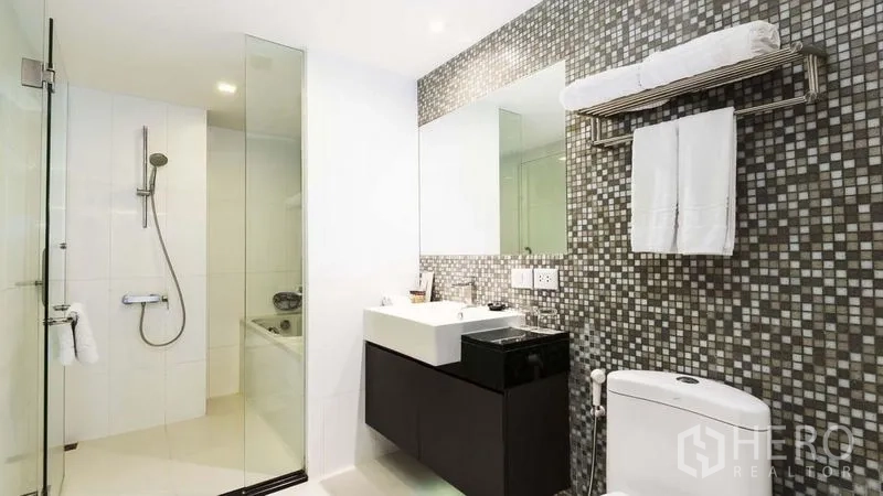 อพาร์ทเมนท์ ให้เช่าในWatthana, Bangkok - ห้องน้ำสมัยใหม่พร้อมฝักบัวกระจก ผนังกระเบื้องโมเสค อ่างล้างหน้าและโถสุขภัณฑ์.