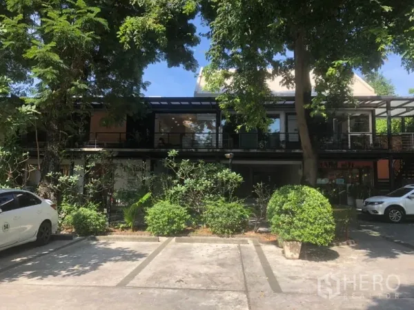 Retail Space for rent in Watthana, Bangkok - Shaded parking bays and landscaped trees in front of a low-rise retail row.
