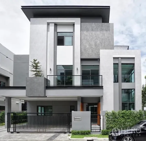 Detached House for rent or sale in Phra Khanong, Bangkok - Contemporary three-storey detached house exterior with balcony, large windows and a gated driveway.