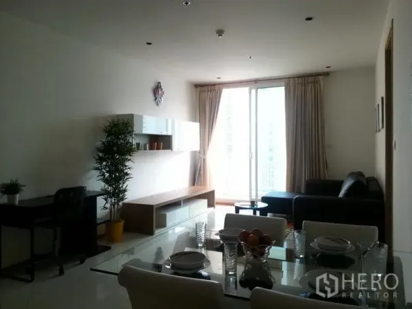 Condominium for rent in Sathon, Bangkok - Bright living and dining area with sofa, media console, and balcony access through floor-to-ceiling sliding doors.