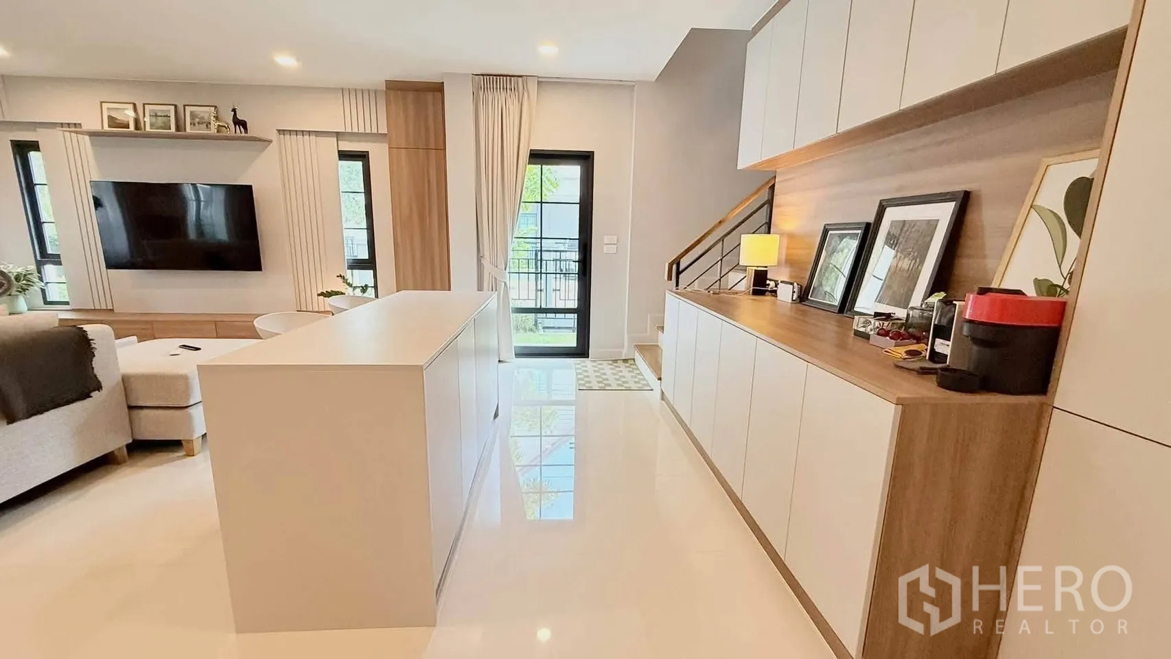 บ้านเดี่ยว for rent in Bang Phli, Samut Prakan - โถงรับแขกแบบเปิดโล่ง มีไอส์แลนด์ ผนังทีวี ตู้บิลต์อิน และบันได