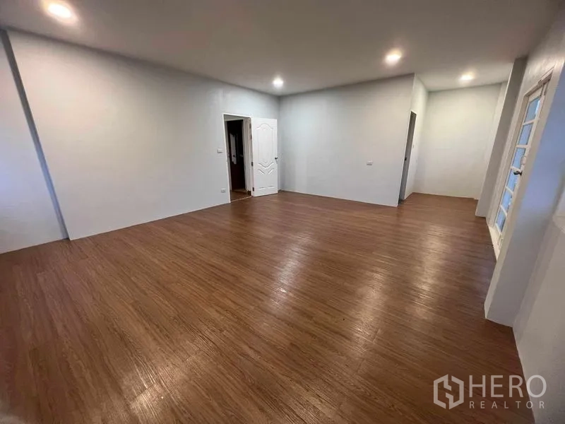 บ้าน ขายในBang Na, Bangkok - ห้องอเนกประสงค์ขนาดใหญ่ พื้นไม้ ไฟฝังฝ้า และประตูหน้าต่างสีขาว