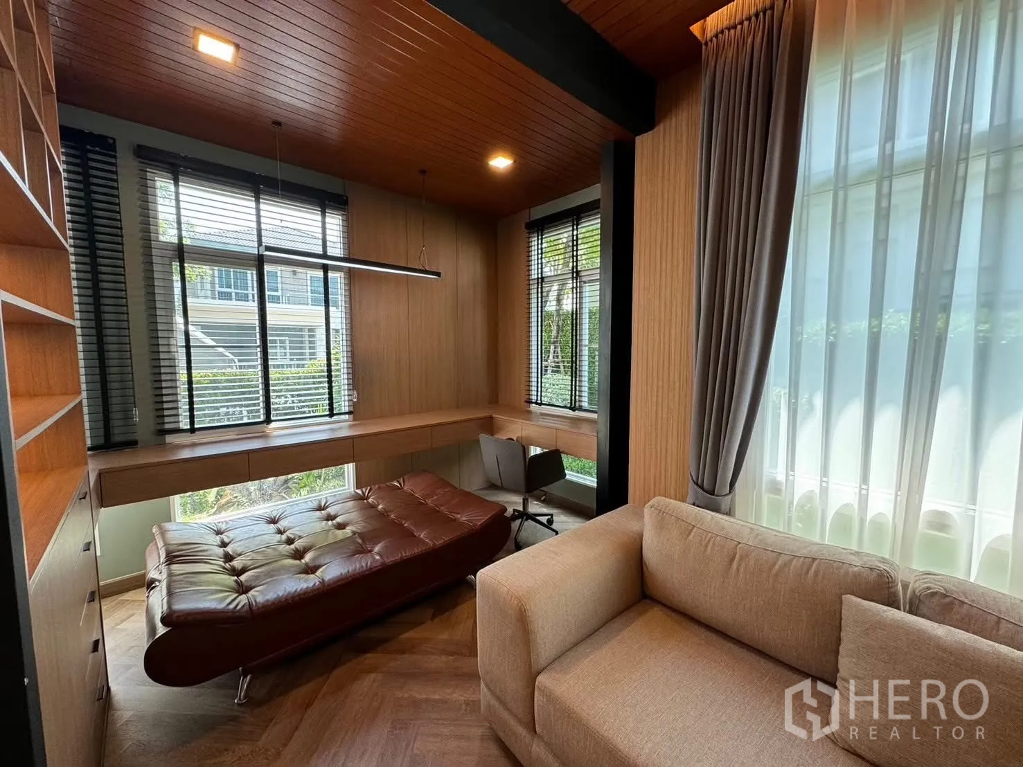 Detached House for rent in Prawet, Bangkok - Spacious living room with sectional sofa and illuminated shelving.