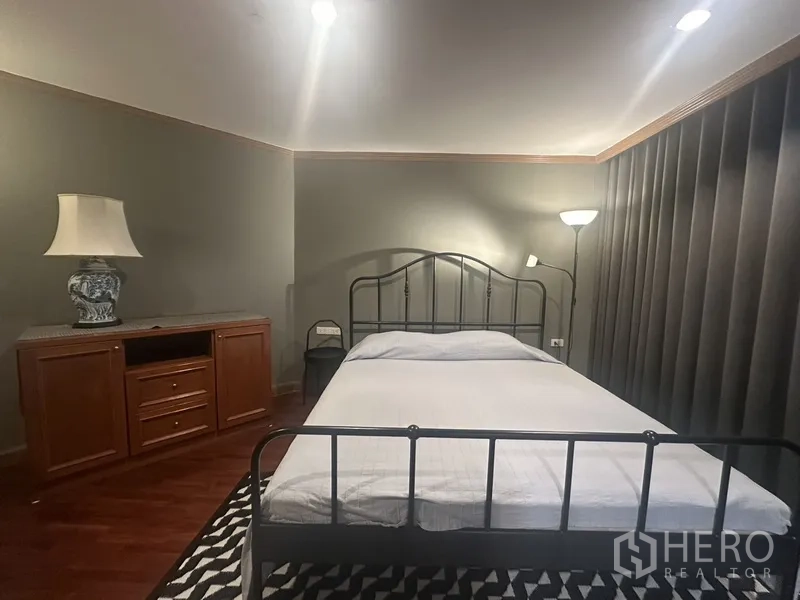 公寓 出售在Watthana, Bangkok - 卧室细节：铁艺床、边柜与落地灯