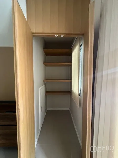 Townhouse for rent in Bang Kapi, Bangkok - Storage closet with built-in wooden shelves and window.