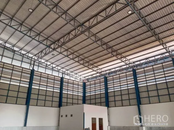 Warehouse for rent in Bang Bo, Samut Prakan - Wide-span warehouse interior with a small built-in office beneath the high roof.