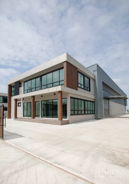 工厂 出租或出售在Bang Len, Nakhon Pathom - 转角视角的新建办公楼，旁为宽阔混凝土场地便于卡车调头。