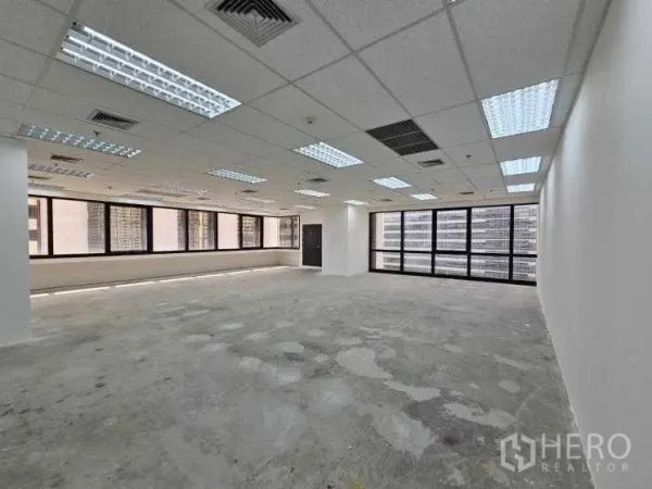 Office Space for rent in Bang Rak, Bangkok - Open workspace with grid ceiling, air vents, and full-height windows on two sides.