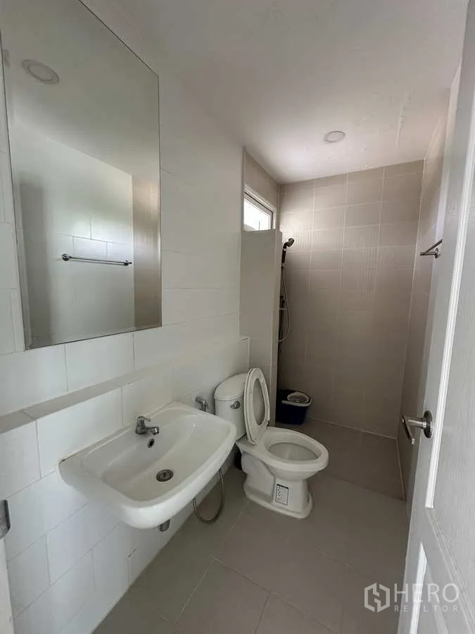 Detached House for rent in Khlong Luang, Pathum Thani - Ground-floor bathroom with shower zone, toilet and wall mirror.