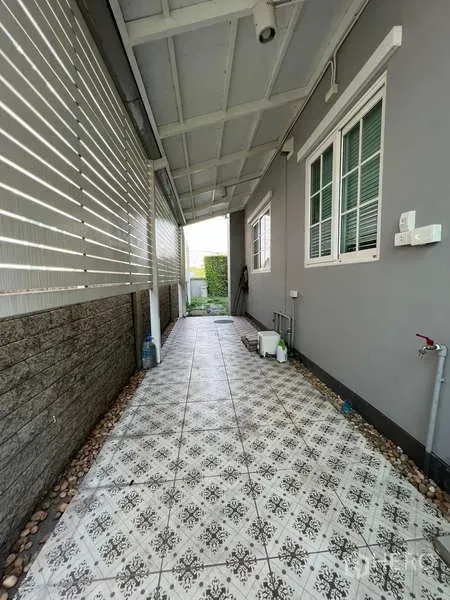 Detached House for rent or sale in Khan Na Yao, Bangkok - Covered side walkway with patterned tiles, privacy screen and service area.