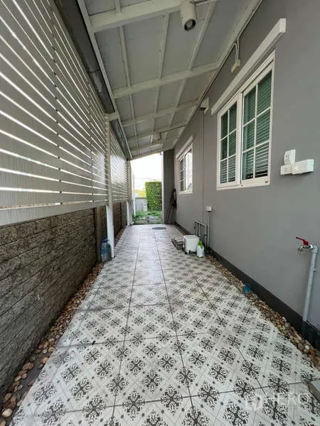 Detached House for rent or sale in Khan Na Yao, Bangkok - Covered side walkway with patterned tiles, privacy screen and service area.