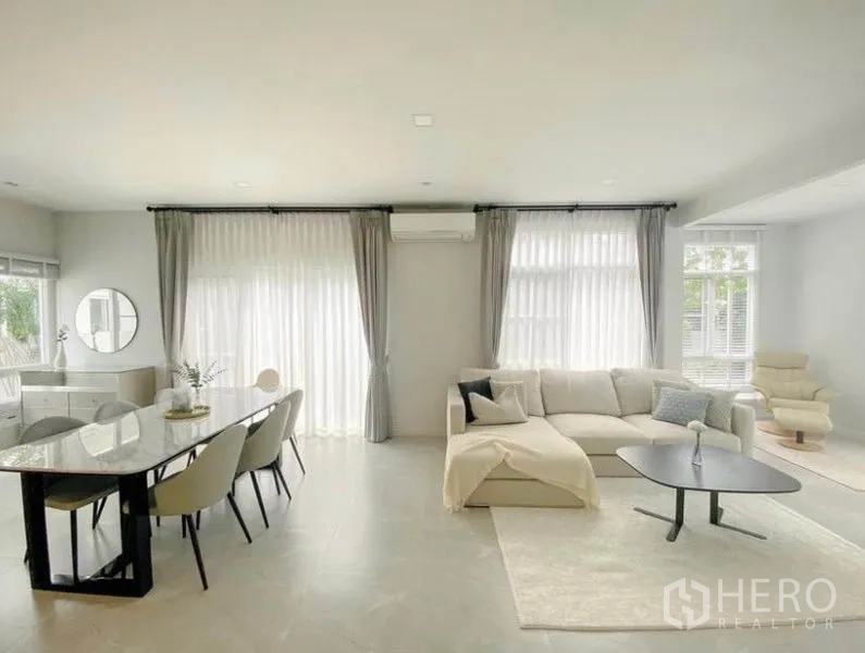 独立式住宅 出租在Prawet, Bangkok - 采光充足的一体化客餐厅，设大窗帘与L形沙发。