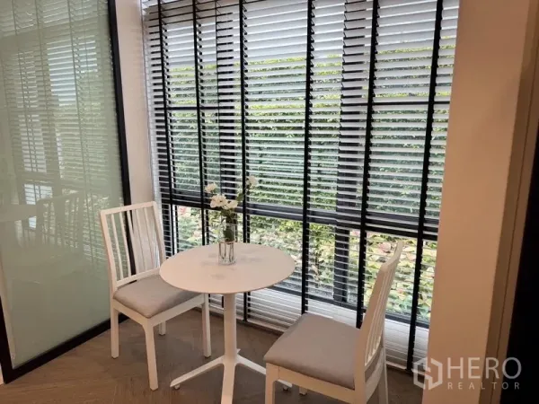 Detached House for rent or sale - Bright breakfast nook with a round table and two chairs beside full-height blinds.