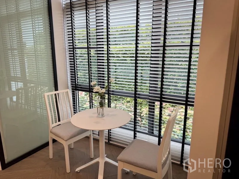 Detached House for rent or sale - Bright breakfast nook with a round table and two chairs beside full-height blinds.