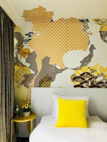 Townhouse for rent in Khlong Toei, Bangkok - Cozy single bedroom with patterned map feature wall and yellow accents.