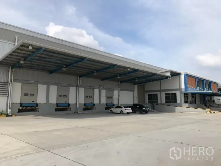 Warehouse for rent in Bang Phli, Samut Prakan - Bang Phli logistics warehouse exterior with covered loading docks and a wide truck yard.