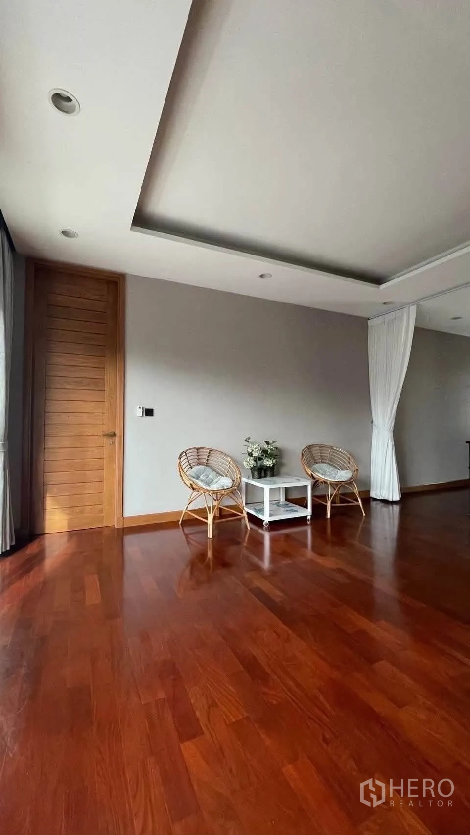 Detached House for rent in Prawet, Bangkok - Upstairs sitting corner with two rattan chairs and side table on wood floors.