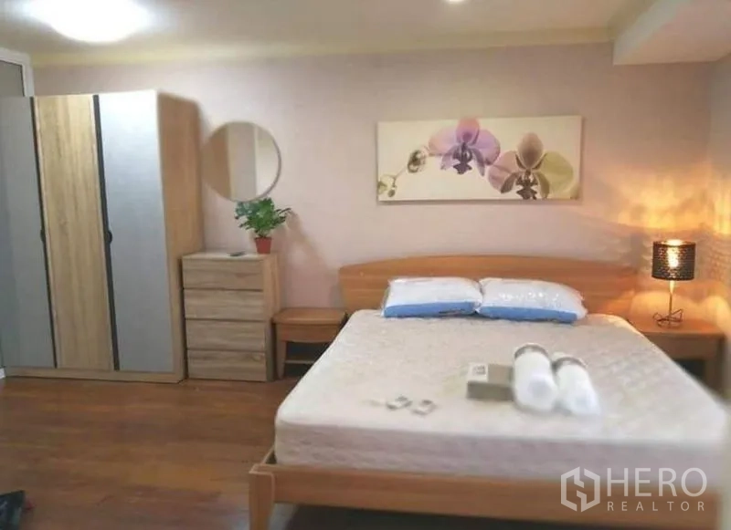 公寓 出租在Khlong Toei, Bangkok - 主卧配木质床、柔和灯光与衣柜