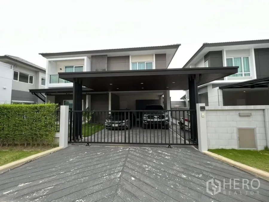 独立式住宅 出租或出售在Lat Krabang, Bangkok - 现代两层独栋住宅，带黑色大门和宽敞的遮棚车位。