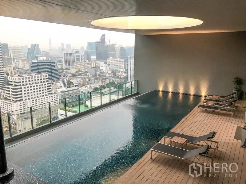 公寓 出租在Bang Rak, Bangkok - 屋顶无边际泳池，设躺椅，俯瞰曼谷天际线。