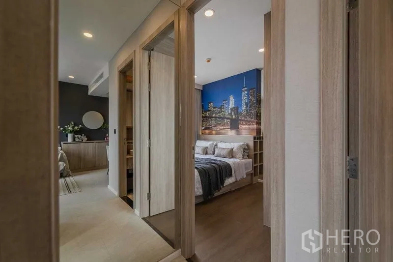 Condominium for rent in Pathum Wan, Bangkok - Hallway leading to master bedroom showcasing a striking skyline mural above the bed.