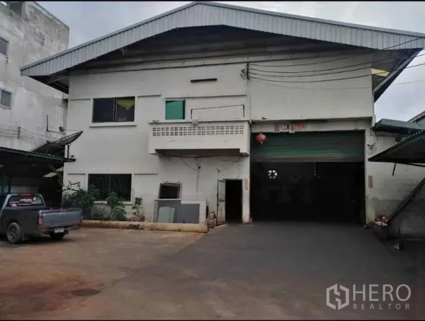 货栈 出租在Prawet, Bangkok - 仓库及办公室正立面，带车道与大型卷帘门。