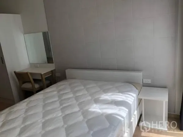 Condominium for rent in Watthana, Bangkok - Bedroom with white bed, bedside table, wardrobe and dressing desk in neutral tones.