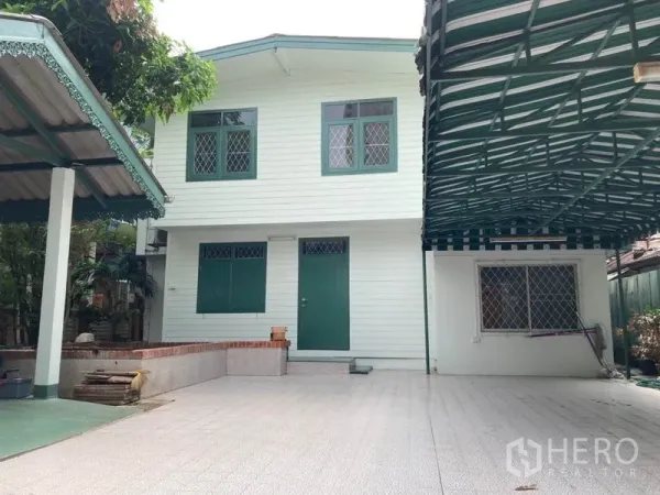 独立式住宅 出租在Sathon, Bangkok - 白色两层独栋住宅，绿色窗框，配宽敞瓷砖庭院。